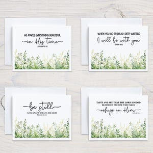 May include: Four white greeting cards with envelopes. Each card features a different inspirational quote in black script, with floral and greenery illustrations at the bottom. The quotes include: "He makes everything beautiful in His time," and "When you go through deep waters I will be with you."