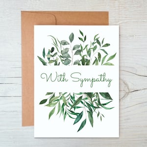 May include: A sympathy card with a white background and green watercolor foliage. The card reads "With Sympathy" in green cursive.