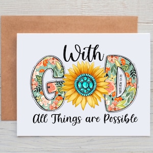 May include: A white card with a floral design that spells out the word "God" with a sunflower in the middle. The text "With God All Things Are Possible" is written below the floral design.