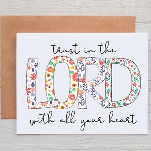 May include: White card with the text "trust in the LORD with all your heart". The word "LORD" is in large, colorful letters with a floral pattern.