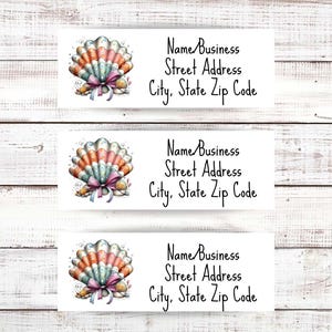 May include: Three white address labels with a seashell design. Each label features a watercolor seashell in shades of orange, pink, and blue, tied with a pink and blue ribbon. The labels also include the text: Name Business, Street Address, City, State Zip Code.