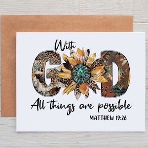 May include: A white card with the words "With God All things are possible Matthew 19:26" printed in black. The word "God" is stylized with a sunflower in the center and each letter is decorated with a different pattern.