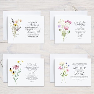 May include: Four white greeting cards with floral watercolor designs and inspirational quotes. Each card features a different arrangement of flowers in shades of purple, yellow, and pink, with accompanying text.