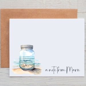 May include: A white card with a watercolor illustration of a mason jar filled with ocean water and a starfish. The text "a note from Marie" is printed at the bottom of the card.