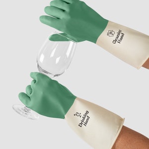 May include: A pair of green and white cleaning gloves with the text "Drinking Hand" on the white part of the glove. The gloves are being used to hold a clear glass.
