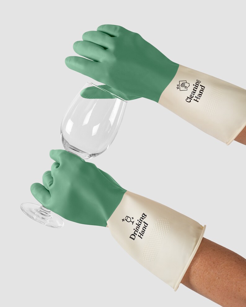 May include: A pair of green and white cleaning gloves with the text "Drinking Hand" on the white part of the glove. The gloves are being used to hold a clear glass.