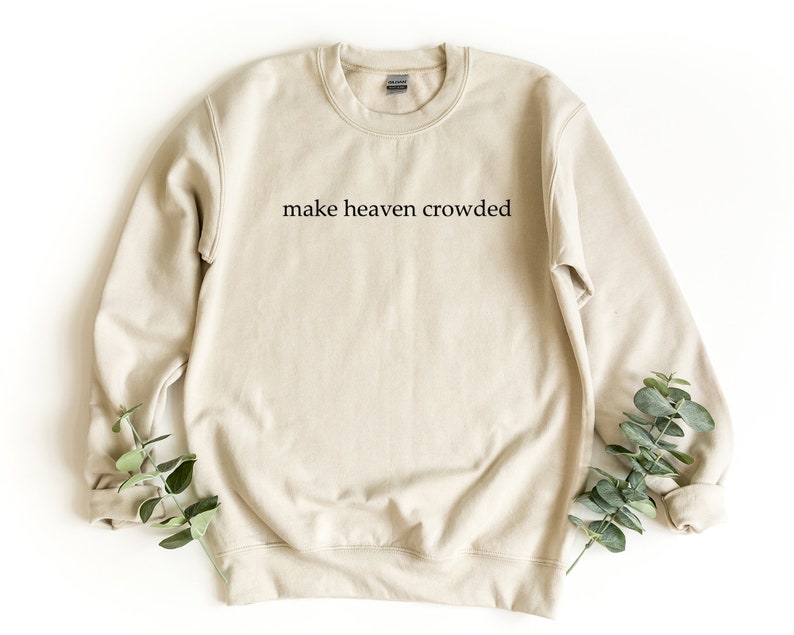May include: A beige sweatshirt with the text "make heaven crowded" printed on the front.