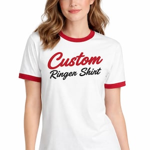 A woman wearing a white t-shirt with red trim and the text "Custom Ringer Shirt" printed on it.