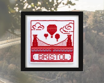 May include: A red and white cross-stitch design of the Clifton Suspension Bridge in Bristol, England. The design includes hot air balloons and the word "BRISTOL" in red.