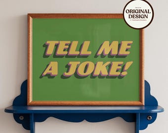 May include: A framed print with the text "TELL ME A JOKE!" in yellow and purple lettering on a green background. The print is displayed on a blue shelf against a white wall. A circular sticker in the upper right corner reads "ORIGINAL DESIGN".