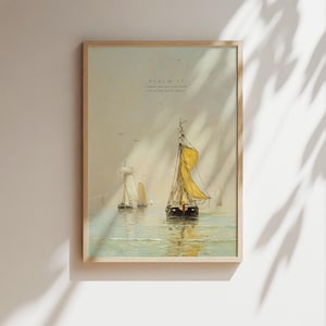 May include: Framed nautical art print featuring sailboats on the water under a hazy sky. The central boat has a yellow sail. The text "Psalm 37" is visible at the top. The artwork is in a light wooden frame.