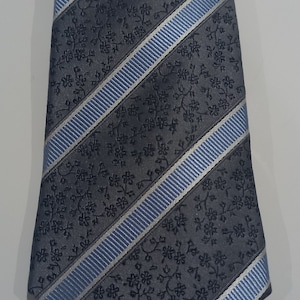 May include: A gray and blue patterned tie with a diagonal stripe design. The tie has a floral pattern.