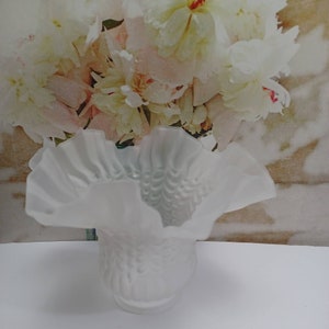 May include: White frosted glass vase with a ruffled top and a textured design. The vase is empty.