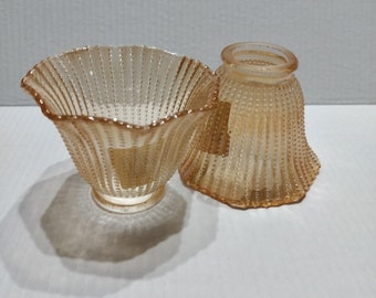 May include: Two amber glass lampshades with a textured, beaded design. The lampshades are in the shape of a bell and a bowl.
