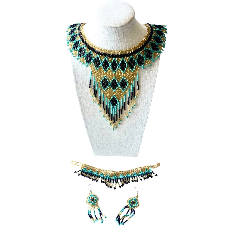May include: A beaded jewelry set featuring a necklace, bracelet, and earrings. The necklace is displayed on a mannequin and has a collar design with black, gold, and turquoise beads. The bracelet and earrings mirror the necklace's design.