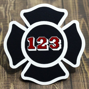 May include: Black and white firefighter's badge with the number 123 in red.