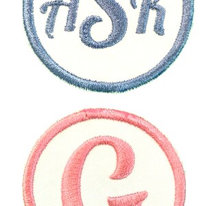 K&ouml;nnte beinhalten: Zwei gestickte Aufn&auml;her, einer mit einem blauen "Sh" in einem wei&szlig;en Kreis mit einem blauen Rand, und der andere mit einem rosa "C" in einem wei&szlig;en Kreis mit einem rosa Rand.