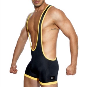 May include: Black singlet with yellow trim. The athletic garment features a scoop neck and a racerback design. The trim is visible around the neckline, armholes, and leg openings. The word "BALE" is printed on the lower left side.