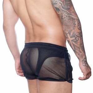 May include: Navy blue mesh shorts with a drawstring waistband and a contrasting trim. The shorts have a sporty design and are made of a sheer, breathable fabric. The garment is designed for comfort and style.