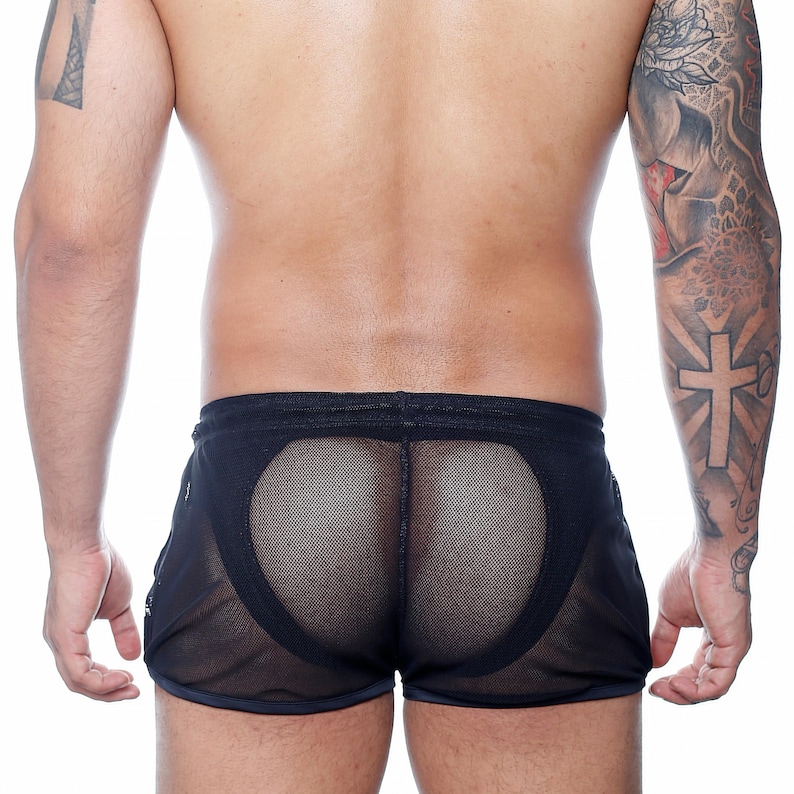 May include: Black mesh shorts with a semi-sheer design. The shorts feature a drawstring waistband and a contrasting trim along the edges. The back of the shorts has a unique mesh panel.