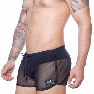 May include: Black mesh shorts with a drawstring waist and a small rectangular patch that reads "DALE" with a red cross. The shorts have a sporty design with black trim.
