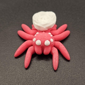 Juguete sensorial impreso en 3D con forma de araña rosa, cuerpo rosa intenso, ojos blancos y diseño de rosa: alivio de la ansiedad, el autismo, el TDAH y la ASMR