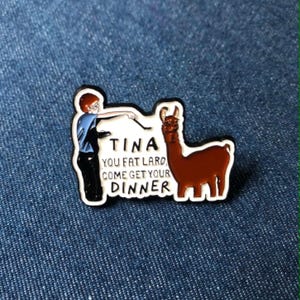 May include: A rectangular enamel pin with a white border. The pin features a cartoon figure pointing at a brown llama. Text on the pin reads "TINA YOU FAT LARD COME GET YOUR DINNER."