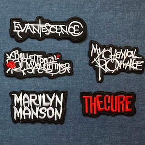 May include: Five embroidered patches featuring band names: Evanescence, Bullet for My Valentine, My Chemical Romance, Marilyn Manson, and The Cure. Each patch has a black background with white or red lettering.