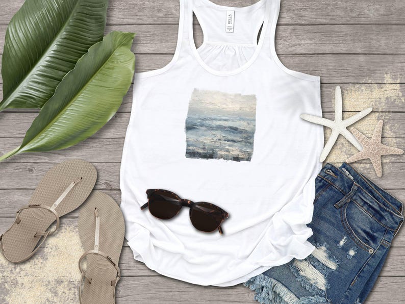 May include: White tank top with a square ocean painting, sunglasses, denim shorts, and flip-flops. The image includes a starfish and large green leaves, creating a beachy, summery vibe. The tank top features a square painting of the ocean.