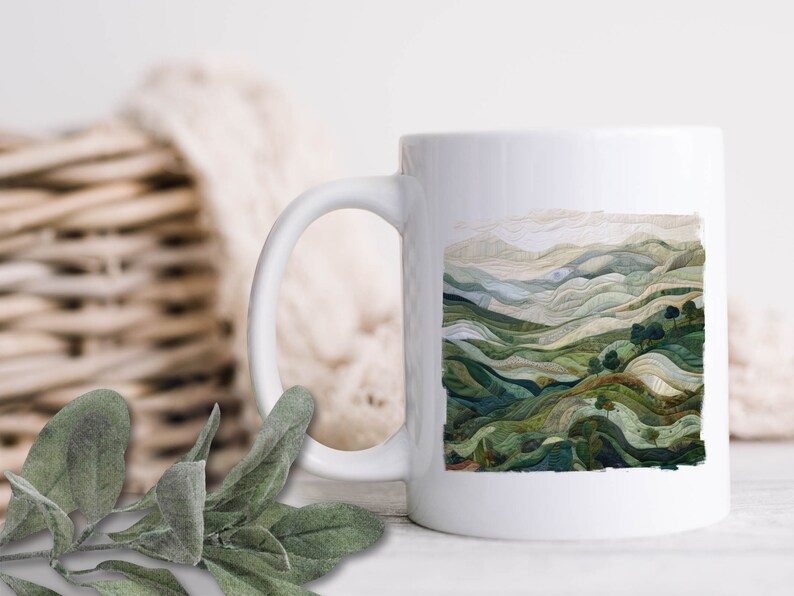 May include: White ceramic mug with a green and brown landscape design. The design features rolling hills and trees.