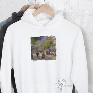 May include: White hoodie with a printed image of a street scene in Paris, France. The image is in a distressed style with a white border.