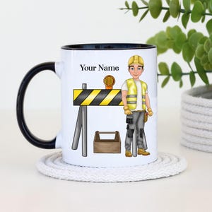Pode incluir: Caneca de cerâmica branca com borda e alça pretas. A caneca apresenta uma ilustração de desenho animado de um trabalhador da construção civil vestindo um colete amarelo e capacete, em pé em frente a uma barreira de construção amarela e preta. O texto "Your Name" está impresso na caneca.