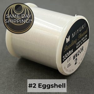 May include: A spool of white Miyuki beading thread made of 100% nylon. The label displays the text 330dtex, Made in Japan, Lot WW20R, and Col 2. The spool is labeled #2 Eggshell. A circular graphic in the corner contains the text SAME DAY SHIPPING!*