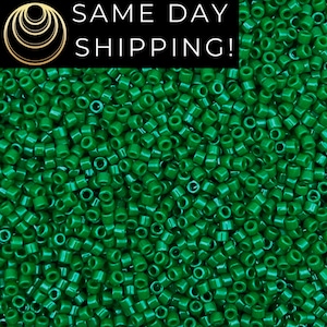 May include: A close-up image of a large quantity of small, round, green beads. The beads are all the same size and shape, and they are arranged in a random pattern.