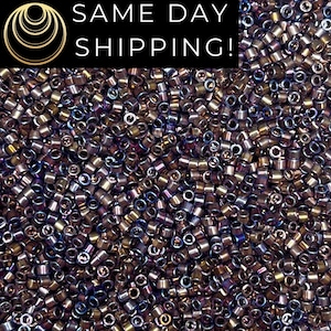 May include: Close-up of a pile of small, cylindrical beads in shades of brown, gold, and purple. The beads have a metallic sheen and are densely packed together. The image includes the text "SAME DAY SHIPPING!"
