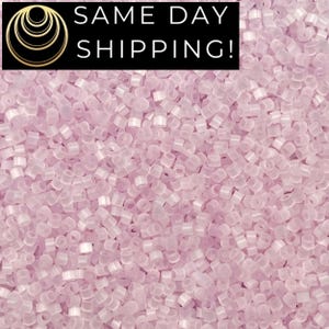 May include: A close-up of a pile of small, translucent, light pink beads. The beads are cylindrical with a hole running through the center. The text "SAME DAY SHIPPING!" is in a black rectangle at the top.