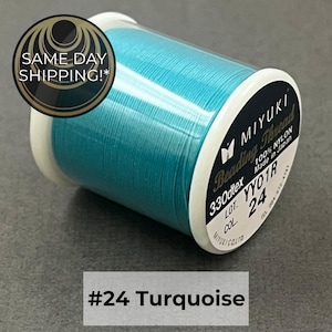 May include: A spool of turquoise beading thread by Miyuki. The label reads 100% nylon, 330dtex, lot YY01R, and color 24. The thread is wound on a white plastic spool. The text #24 Turquoise is displayed below the spool on a gray background.
