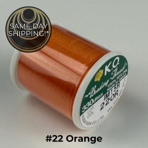 May include: A spool of vibrant orange K.O. Beading Thread made of 100% nylon. The label on the white plastic spool indicates 330dtex, color code 220R, and that it is made in Japan. The text #22 Orange is printed below the spool.