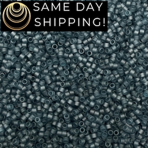 May include: A large collection of small, cylindrical, matte dark gray beads with a uniform shape and central hole. A black rectangular overlay at the top features a gold circular logo and the white text SAME DAY SHIPPING!