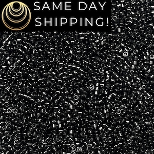 May include: A large collection of small, cylindrical, metallic black glass seed beads with a reflective, glossy finish. The image includes a black rectangular banner at the top with the white text SAME DAY SHIPPING! and a gold circular logo.
