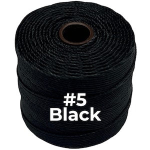 May include: A cylindrical spool of black cord featuring a tightly wound, textured surface. The center of the spool has a dark brown circular core. The text #5 Black is printed in white, bold, sans-serif font on the front of the black cord.