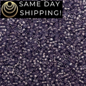 May include: A close-up shot of a pile of small, cylindrical beads in a dark purple hue. The beads are uniform in size and shape, with a small hole running through the center of each. The image includes the text "SAME DAY SHIPPING!" in white letters on a black background.