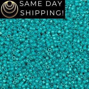 May include: A close-up image of a large quantity of turquoise blue seed beads. The beads are small and round, and they are all the same size. The beads are arranged in a random pattern, and they are all in focus.