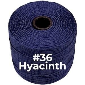 May include: A spool of dark purple twisted cord featuring a black center core. The text #36 Hyacinth is printed in white on the front of the cord spool, indicating the specific color and size of the craft material.