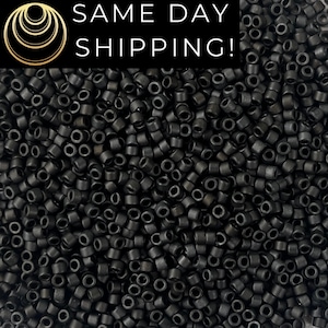 May include: A close-up shot of a large pile of small, black, cylindrical beads. The beads are densely packed together, filling the frame. The image has a dark, matte appearance. The text "SAME DAY SHIPPING!" is displayed in white on a black background in the upper portion of the image.