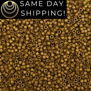 May include: A large quantity of small, round, gold-colored beads. The beads are all the same size and shape, and they are arranged in a random pattern.