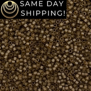 May include: A close-up image of a large quantity of small, round, brown beads. The beads are all the same size and shape, and they are arranged in a random pattern.