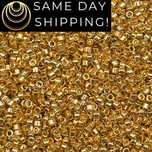 May include: Close-up of a pile of small, shiny, gold-colored beads. The beads are cylindrical with a hole running through the center. The text "SAME DAY SHIPPING!" is displayed in a black rectangle at the top.