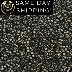 May include: A large collection of small, cylindrical, metallic dark gray beads with a matte finish. The beads are densely packed together, showing their uniform shape and central holes. A black banner at the top displays the text SAME DAY SHIPPING!