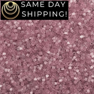 May include: Close-up of a pile of small, translucent, light purple beads. The beads are cylindrical with a hole running through the center. The image has a black banner at the top with the words "SAME DAY SHIPPING!"